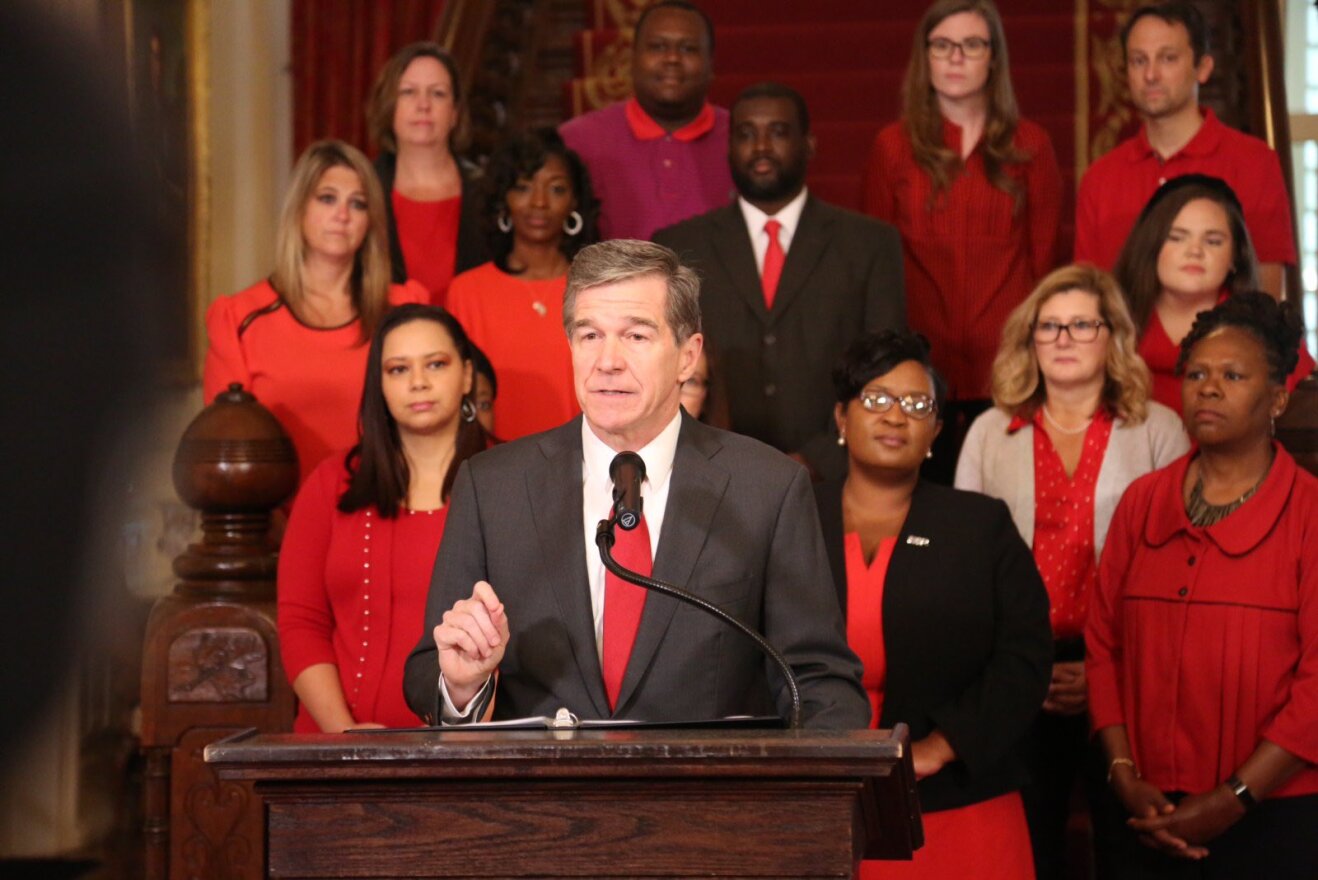Flanked by educators dressed in red on November 8, Gov. Roy Cooper vetoed four bills that he said "prioritized more corporate tax cuts over a real teacher pay raise and urged legislators to come together and come up with a compromise."